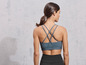 Une femme porte un soutien-gorge de sport bleu et un legging noir.