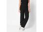 Pantalon noir ample avec des baskets blanches.