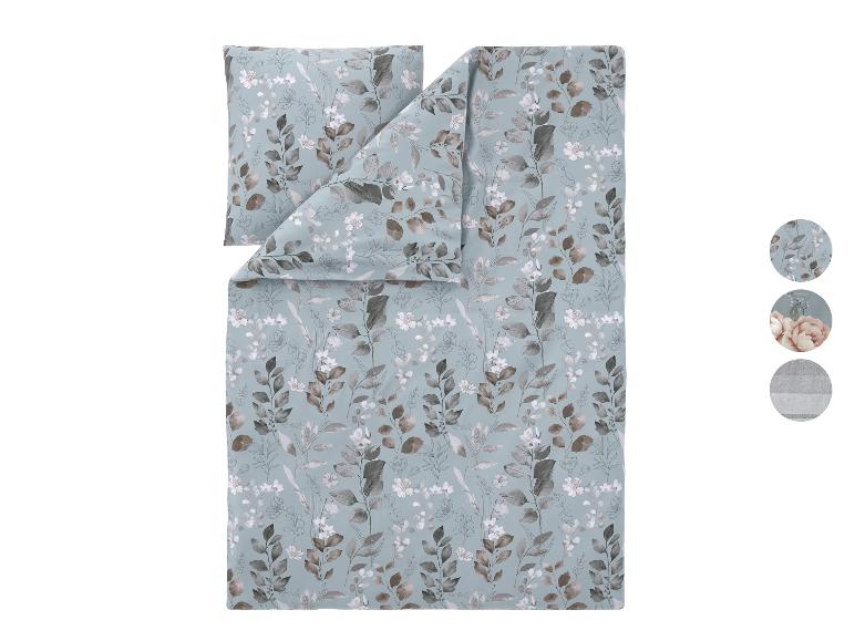 Parure de lit avec motif de fleurs et feuilles marron et blanches sur fond bleu.