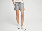 Une femme portant un short de sport gris et des baskets blanches.