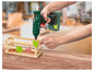Une main utilise un pistolet à colle Parkside pour coller des cœurs décoratifs sur une boîte en bois.
