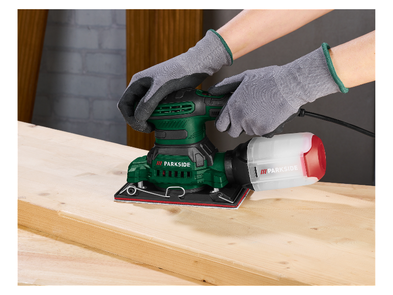 Une personne utilise une ponceuse orbitale Parkside pour poncer une planche de bois.