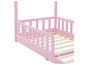 Un lit en bois rose avec des barreaux.