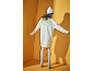Femme de dos en robe-pull tricotée blanche, bonnet et chaussettes hautes sur fond jaune.