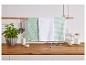 Trois torchons de cuisine verts à motifs différents suspendus à une barre en bois dans une cuisine.