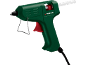 Pistolet à colle chaude vert avec gâchette rouge et bâton de colle blanc.