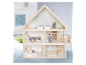 Une jolie maison de poupées en bois à deux étages avec des poupées et des meubles de style scandinave.