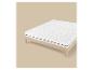 Cadre de lit en bois avec matelas blanc et surmatelas, sur fond beige.