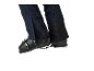 Gros plan d'un pantalon de ski bleu foncé avec des chaussures de ski noires.