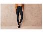 Leggings noirs à côtes, portés avec un pull beige et des mocassins noirs.