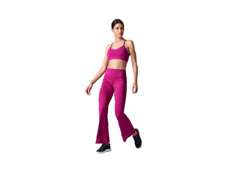 Femme en brassière de sport fuchsia et pantalon évasé