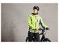 Une femme portant un casque de vélo porte une veste fluorescente et tient un vélo.