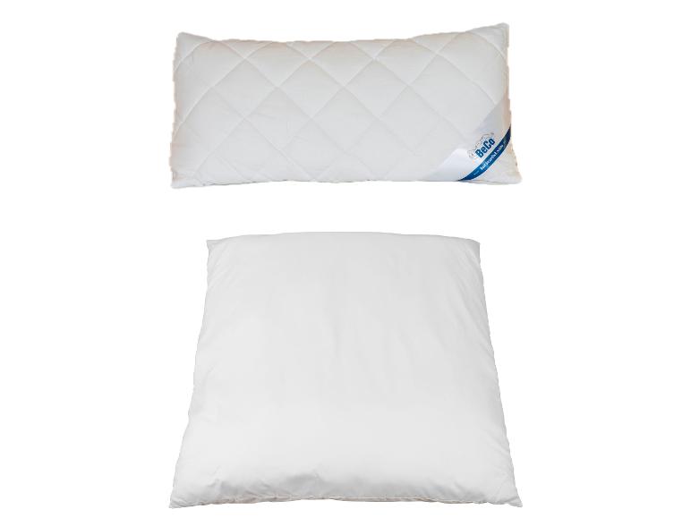Deux oreillers blancs, le supérieur avec une étiquette BeCo et un motif matelassé.
