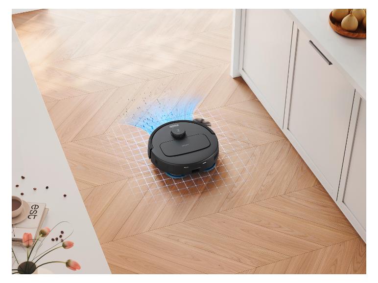 Un robot aspirateur noir nettoie un parquet en bois, avec une simulation de nettoyage visible.