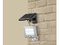 Lampe solaire LED avec détecteur de mouvement, fixée sur un mur de briques beige.