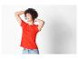 Une femme portant un t-shirt rouge et un jean.