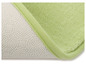 Un tapis de bain vert avec un dessous antidérapant.