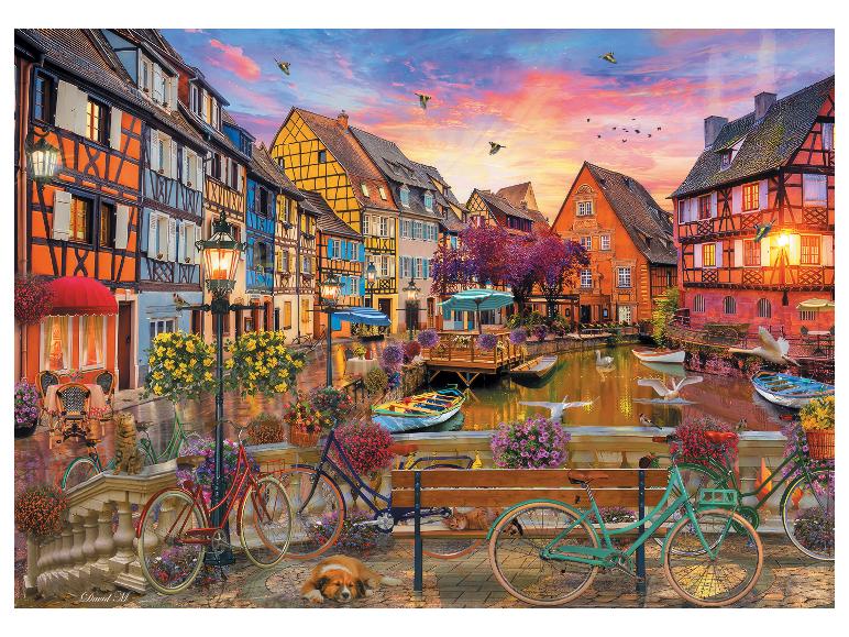 Ville pittoresque avec des maisons colorées, un canal, des bateaux, des vélos et des animaux de compagnie au coucher du soleil.