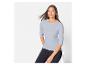 Une femme porte un t-shirt à manches longues bleu clair et un pantalon noir.