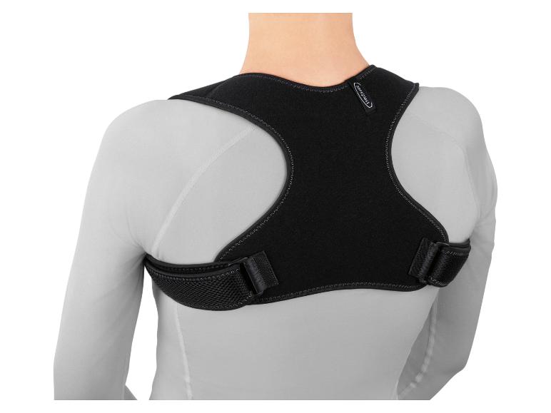 Vue de dos d'une personne portant un correcteur de posture Sensiplast noir sur un t-shirt blanc à manches longues