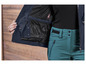 Une veste bleue avec un réflecteur RECCO et un pantalon vert.