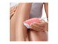 Une femme utilise un épilateur rose sur sa jambe.