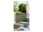 Haie artificielle verte sur un balcon avec une table et des chaises.
