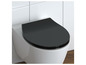 Un abattant de toilettes noir sur des toilettes blanches.