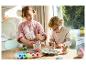 Deux enfants décorent des œufs de Pâques et des figurines de lapin avec de la peinture.
