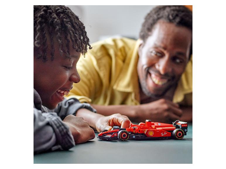 Un enfant et son père jouent avec une voiture de course LEGO Ferrari.