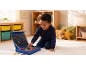 Garçon souriant joue avec des lettres magnétiques sur un tapis dans une chambre d'enfant.