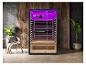 Sauna moderne avec éclairage violet, fauteuil de relaxation et plantes.