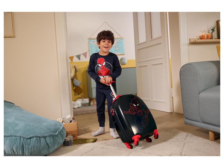 Garçon en pyjama Spiderman tirant une valise enfant Spiderman dans une chambre.