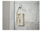 Radio de douche étanche suspendue à un mur de carrelage gris.