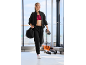 Femme en survêtement noir et soutien-gorge de sport rouge, avec un sac et une bouteille d'eau.