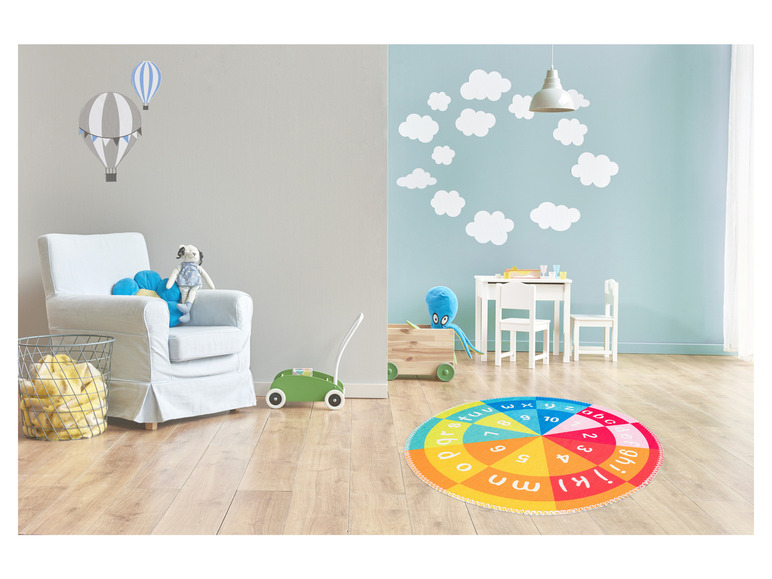 Une chambre d'enfant avec un tapis d'éveil avec des lettres et des chiffres.