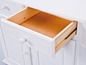 Une commode blanche avec un tiroir ouvert.