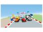 Trois voitures de course LEGO Duplo Formule 1 sur la ligne de départ avec un trophée et une station de mécanicien.