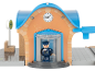 Gare de train jouet avec horloge, entrée tournante et figurine de conducteur.