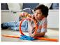 Un enfant joue avec une boucle et une piste Hot Wheels.