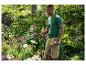 Homme arrosant des fleurs dans un jardin avec un tuyau d'arrosage et un pistolet Parkside.
