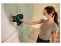 Femme peignant un mur avec un pistolet à peinture sans fil Parkside.