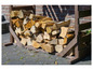 Une pile de bois de chauffage dans un support en bois sur une terrasse.