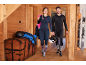 Couple en sous-vêtements thermiques, tenant des casques de ski, avec skis et veste d'hiver.