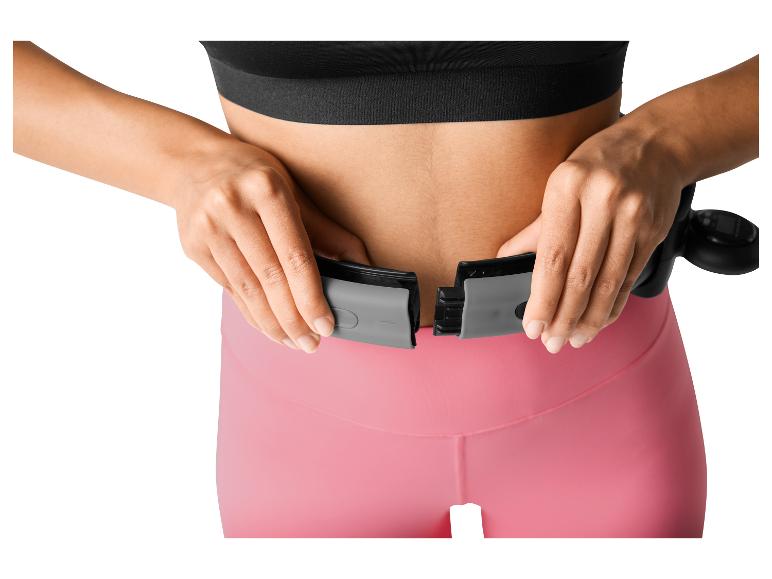 Femme ajustant un cerceau de fitness intelligent autour de sa taille.