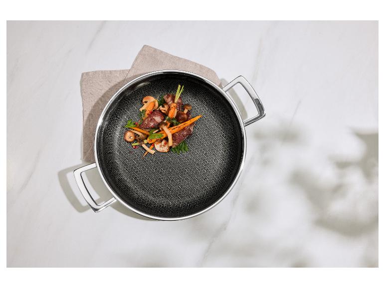 Poêle avec viande, champignons et carottes sur un torchon sur une table en marbre