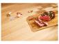 Steak coupé sur planche en bois, assaisonné d'herbes et épices.