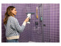 Une femme nettoie une cabine de douche avec un nettoyeur de vitres Karcher.
