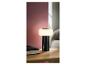 Lampe de table portable noire avec lumière blanche sur une table de chevet en bois à côté d'un livre.