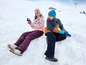 Deux enfants en vêtements d'hiver jouent dans la neige.